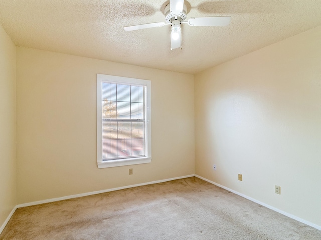 carpeted spare room featuring ceiling fan and a textured ceiling