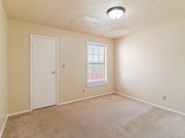 unfurnished room with a textured ceiling and light carpet