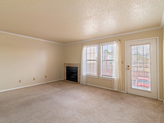 unfurnished living room featuring crown molding, a fireplace, light colored carpet, and a textured ceiling