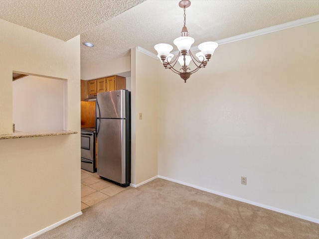 kitchen with appliances with stainless steel finishes, light colored carpet, crown molding, pendant lighting, and a chandelier