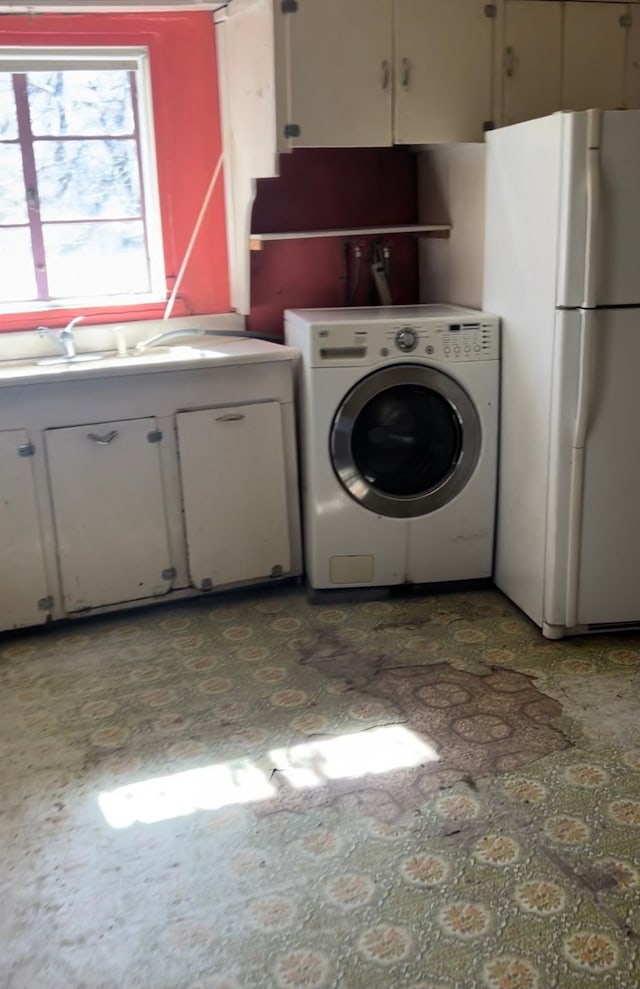 clothes washing area with sink, cabinets, and washer / dryer