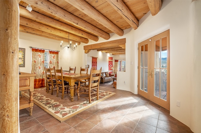 tiled dining room featuring a chandelier, beam ceiling, wooden ceiling, and french doors