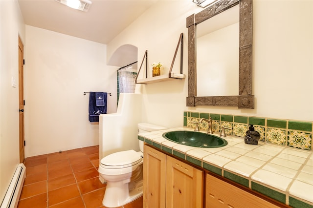 bathroom featuring vanity, backsplash, a baseboard heating unit, tile patterned flooring, and toilet