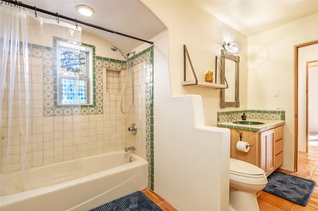 full bathroom with tile patterned flooring, vanity, tiled shower / bath combo, and toilet