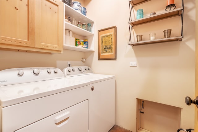 clothes washing area with washer and clothes dryer and cabinets