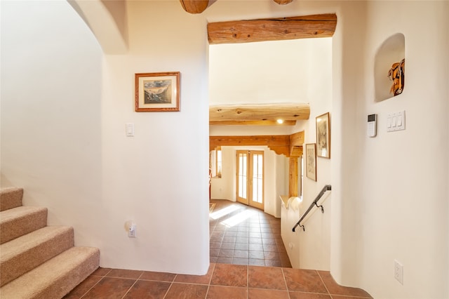 hall featuring a high ceiling and dark tile patterned flooring