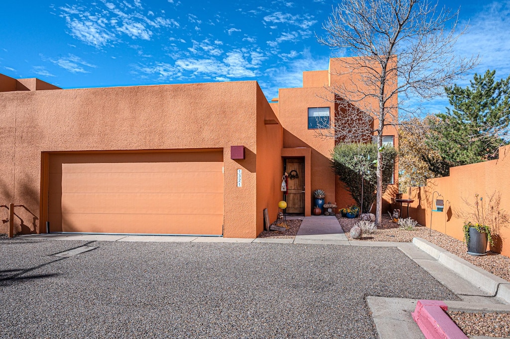 pueblo revival-style home featuring a garage