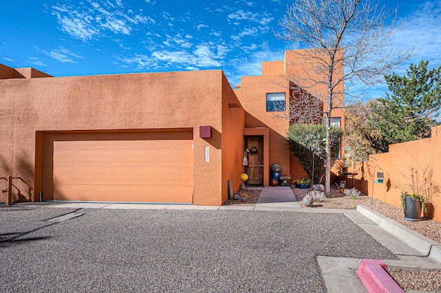 pueblo revival-style home featuring a garage