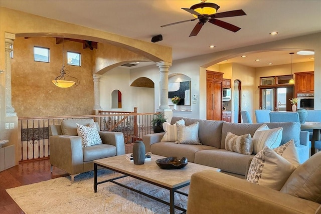 living room featuring decorative columns, hardwood / wood-style flooring, a wealth of natural light, and ceiling fan