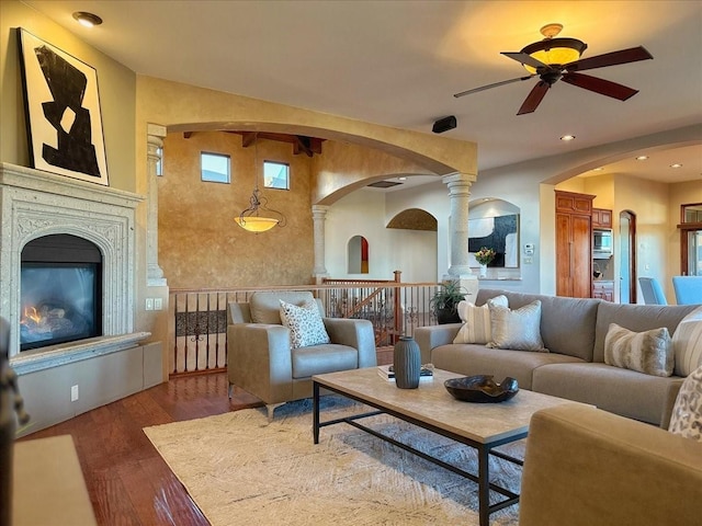 living room featuring hardwood / wood-style floors, decorative columns, and ceiling fan