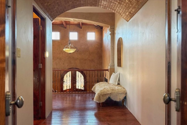 hall featuring french doors, decorative columns, brick ceiling, dark wood-type flooring, and lofted ceiling