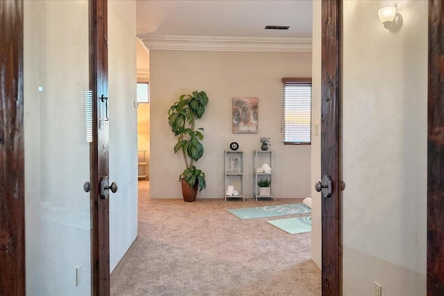 hallway with carpet flooring, crown molding, and french doors