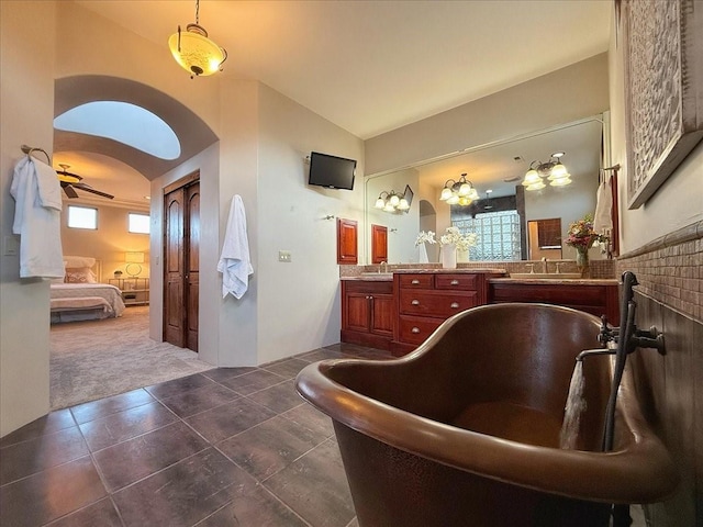 bathroom featuring tile patterned flooring, vanity, lofted ceiling, and a wealth of natural light