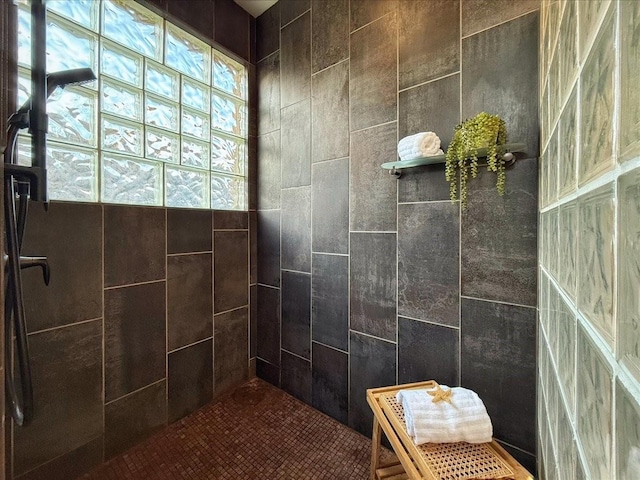 bathroom featuring a tile shower and tile walls