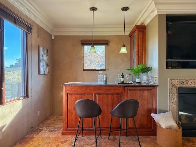 bar featuring hanging light fixtures and crown molding