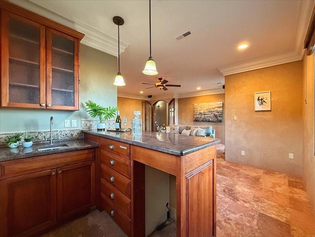 kitchen with sink, ceiling fan, ornamental molding, decorative light fixtures, and kitchen peninsula