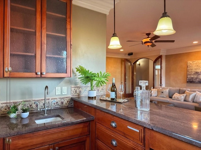 kitchen with pendant lighting, ornamental molding, and sink