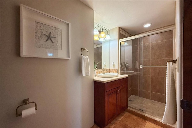 bathroom with tile patterned flooring, a shower with door, vanity, and a notable chandelier