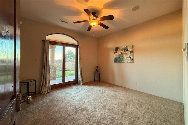 carpeted spare room with ceiling fan