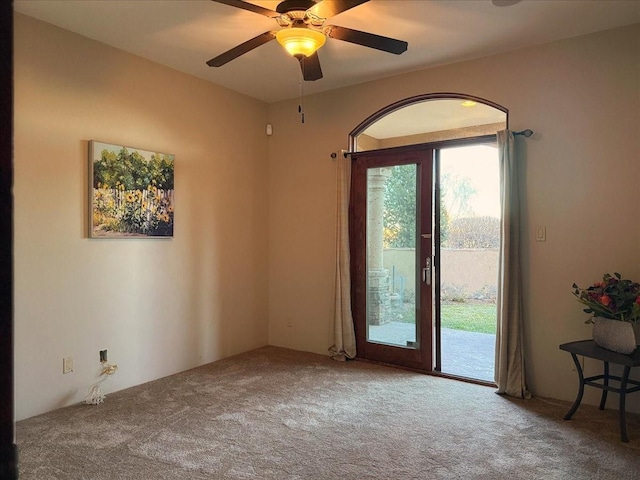 carpeted spare room featuring ceiling fan