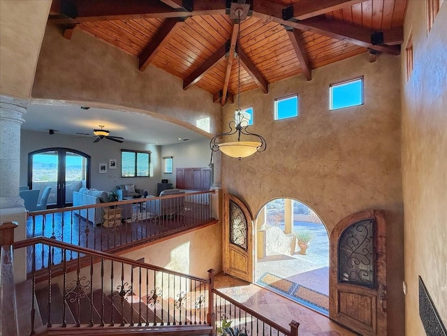 interior space featuring ceiling fan, beam ceiling, wooden ceiling, and high vaulted ceiling