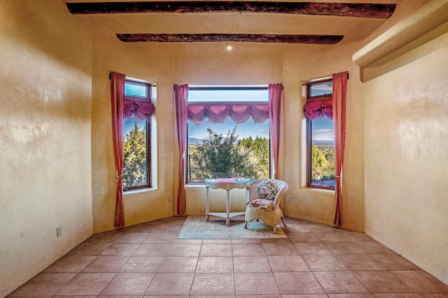 interior space with a wealth of natural light, beamed ceiling, and light tile patterned floors