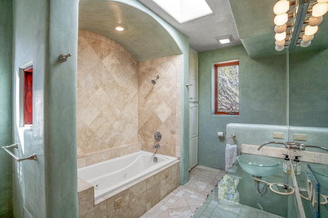 bathroom featuring tile patterned flooring, a skylight, plus walk in shower, and sink