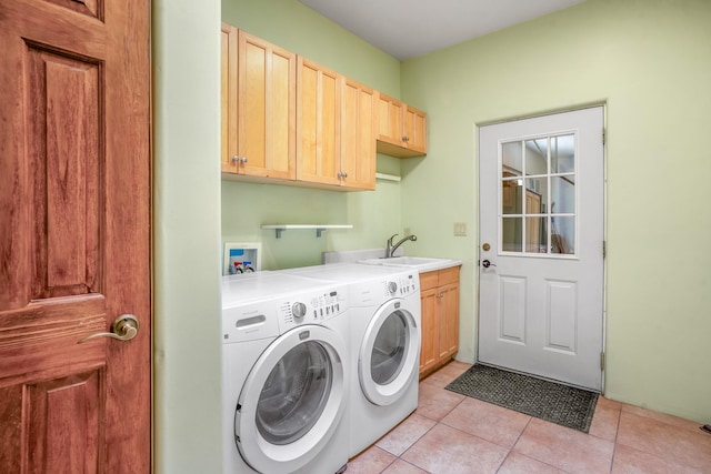 laundry room featuring washer and clothes dryer, light tile patterned flooring, cabinets, and sink