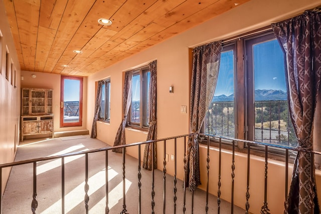 interior space with a mountain view, carpet, and wood ceiling