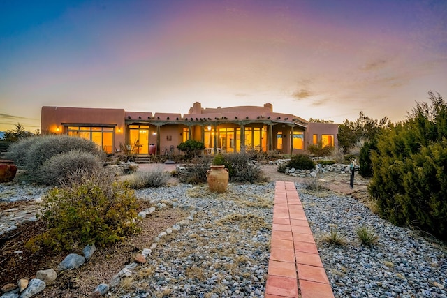 view of back house at dusk