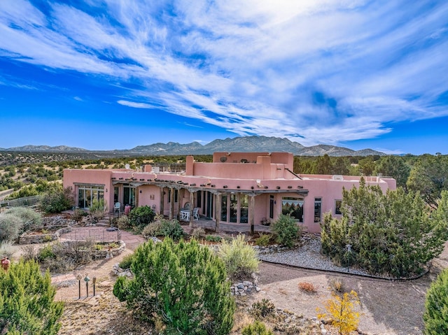 back of house with a mountain view and a patio