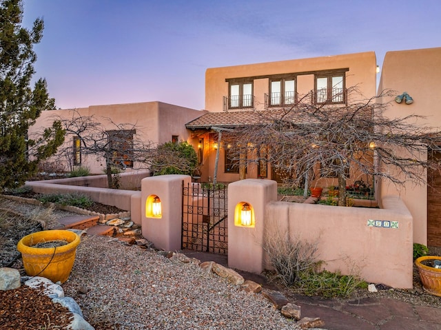 pueblo-style home with a balcony