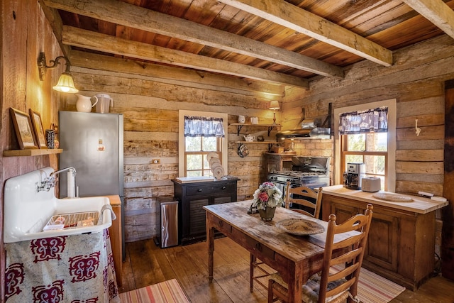 dining space featuring beamed ceiling, hardwood / wood-style floors, and wood ceiling