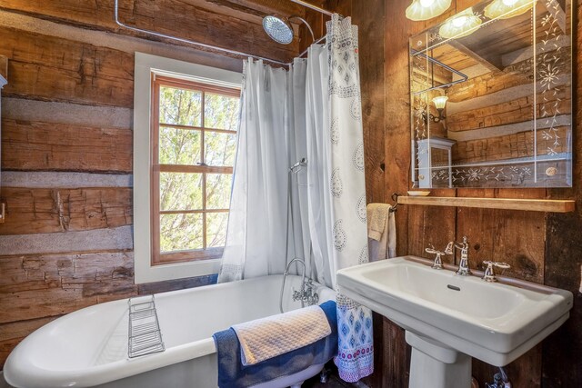 bathroom featuring shower / bath combination with curtain and sink