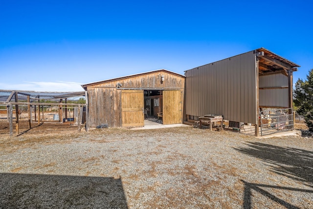 back of property featuring an outdoor structure