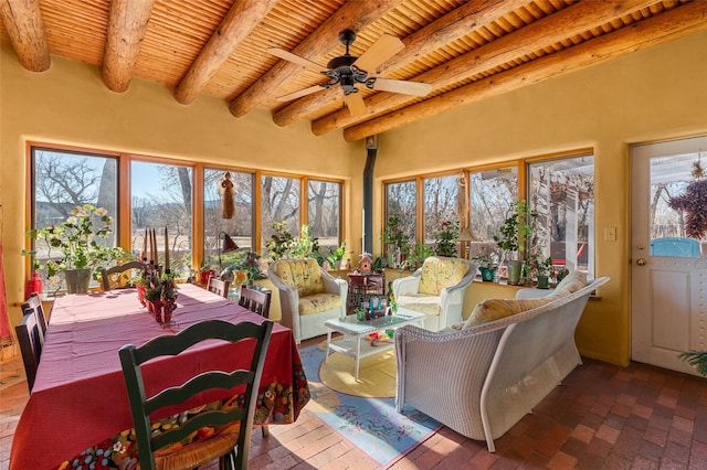 sunroom featuring a healthy amount of sunlight, ceiling fan, wooden ceiling, and beam ceiling