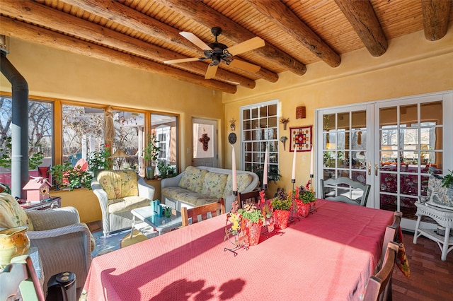 sunroom / solarium featuring ceiling fan, beamed ceiling, wood ceiling, and french doors