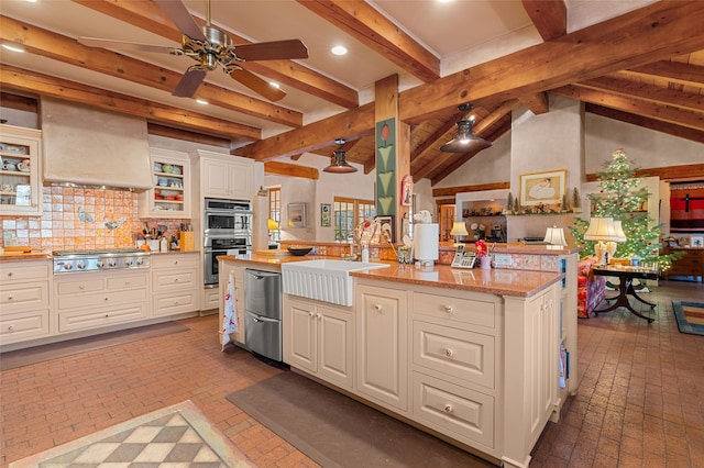 kitchen featuring appliances with stainless steel finishes, sink, wall chimney range hood, white cabinets, and tasteful backsplash