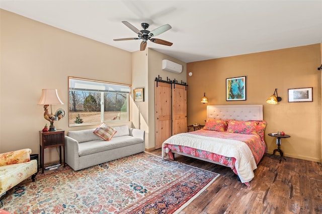 bedroom featuring a wall mounted air conditioner, ceiling fan, dark wood-type flooring, and a barn door