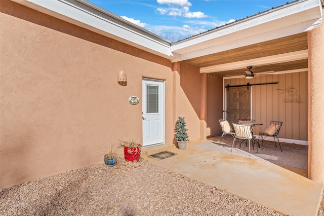 property entrance featuring a patio area and ceiling fan