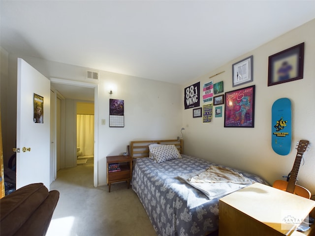 bedroom featuring light carpet and ensuite bathroom