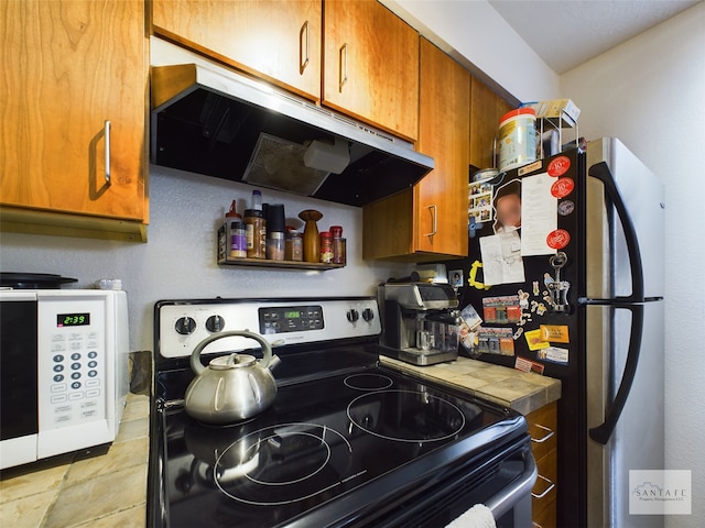 kitchen featuring range hood and stainless steel appliances