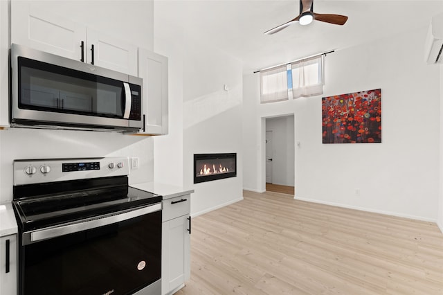 kitchen featuring white cabinets, light wood-type flooring, and appliances with stainless steel finishes