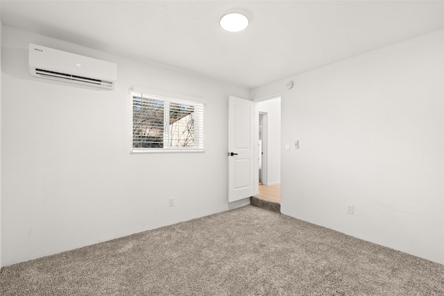 unfurnished room with a wall unit AC and carpet floors