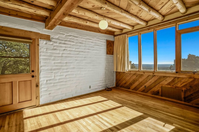 interior space with a healthy amount of sunlight, wooden ceiling, and beam ceiling