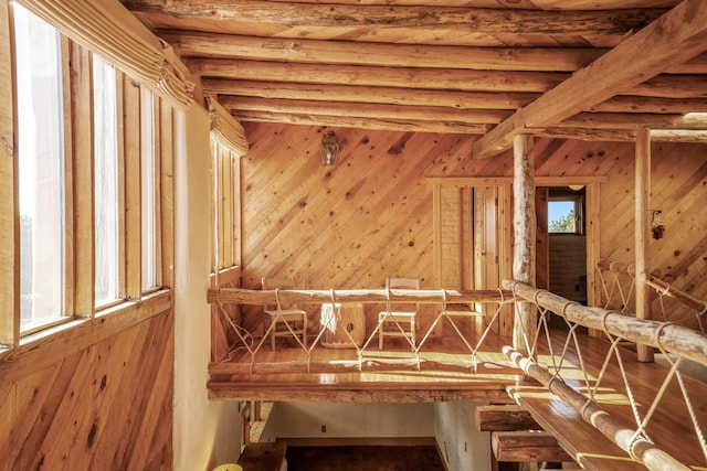 misc room with beam ceiling and wooden walls