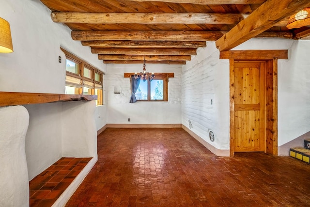 unfurnished dining area with beam ceiling, wooden ceiling, and an inviting chandelier