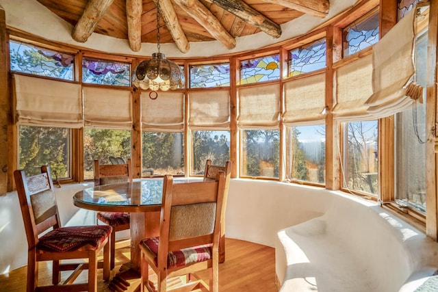 sunroom featuring lofted ceiling with beams, a wealth of natural light, and wood ceiling