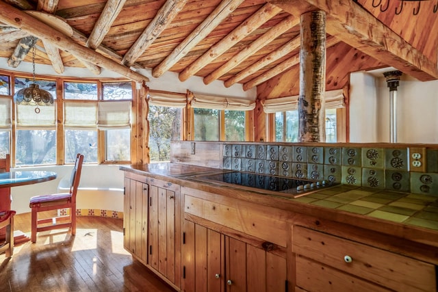 kitchen featuring tile countertops, lofted ceiling with beams, hardwood / wood-style flooring, stovetop, and wood ceiling