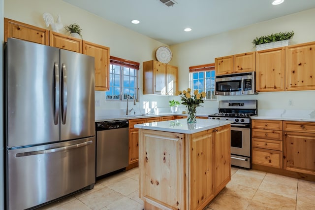 kitchen featuring a center island, stainless steel appliances, plenty of natural light, and sink